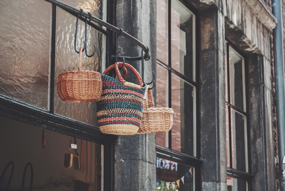 two woven baskets hanging from the side of a building