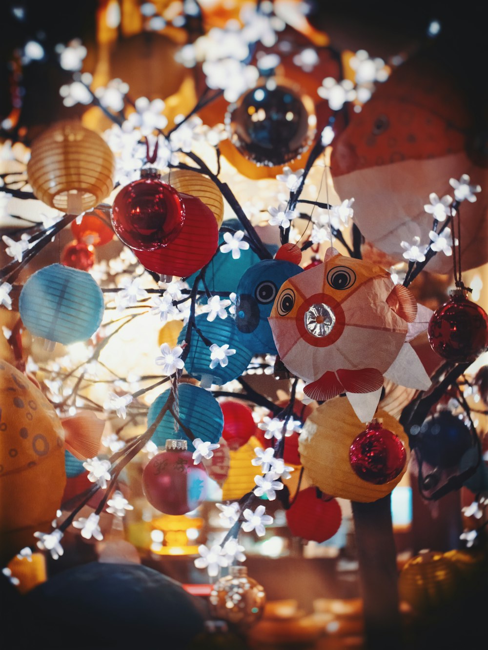 a bunch of paper lanterns hanging from a tree