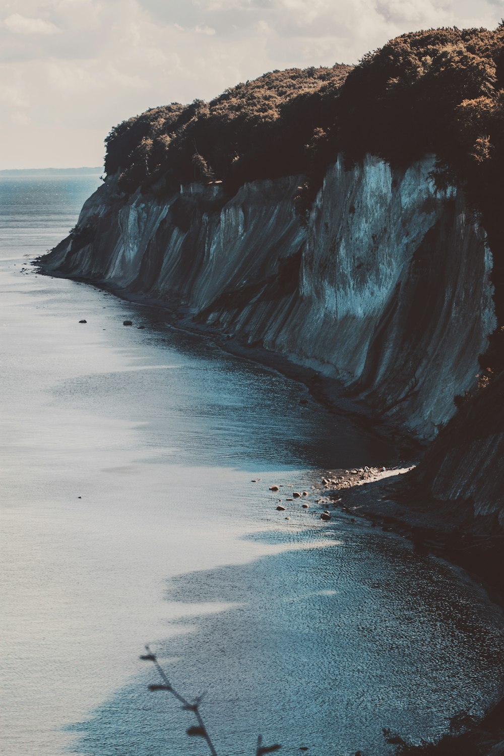 un grande specchio d'acqua vicino a una scogliera