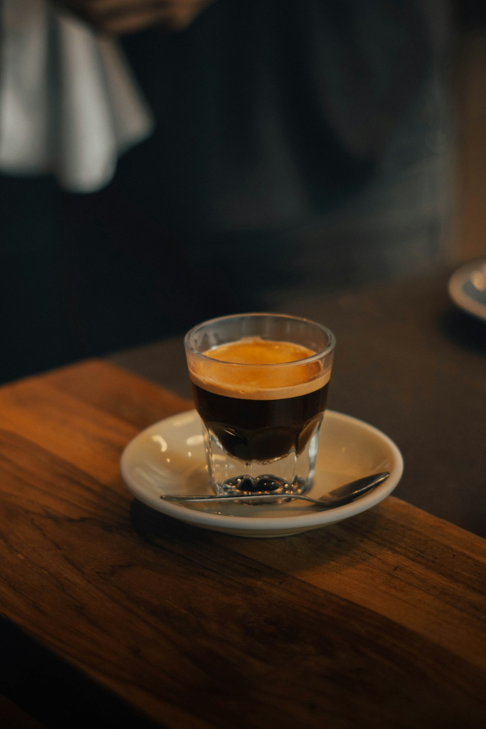 a cup of coffee sitting on top of a white plate