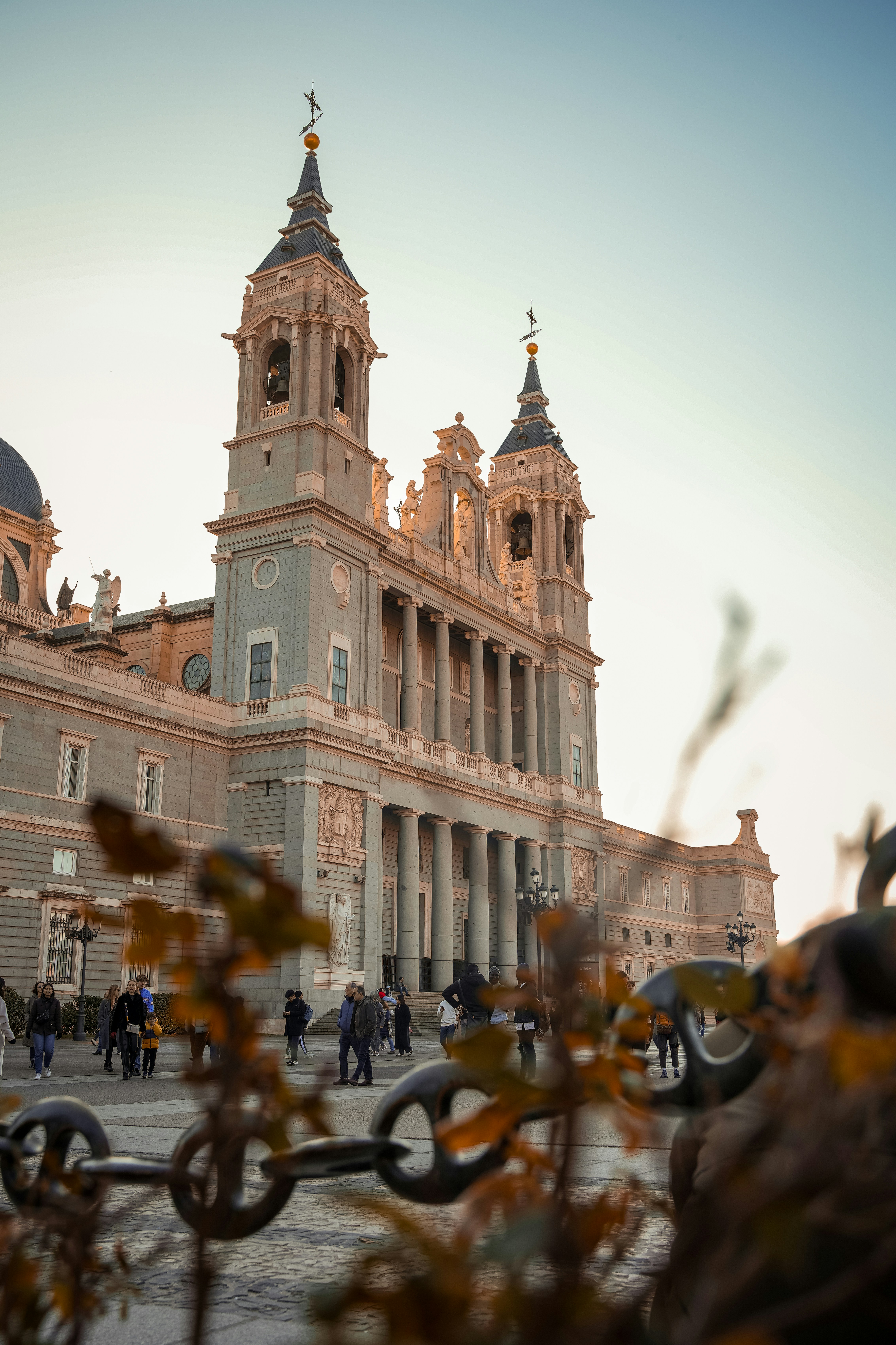 a large building with a clock tower next to a chain link fence