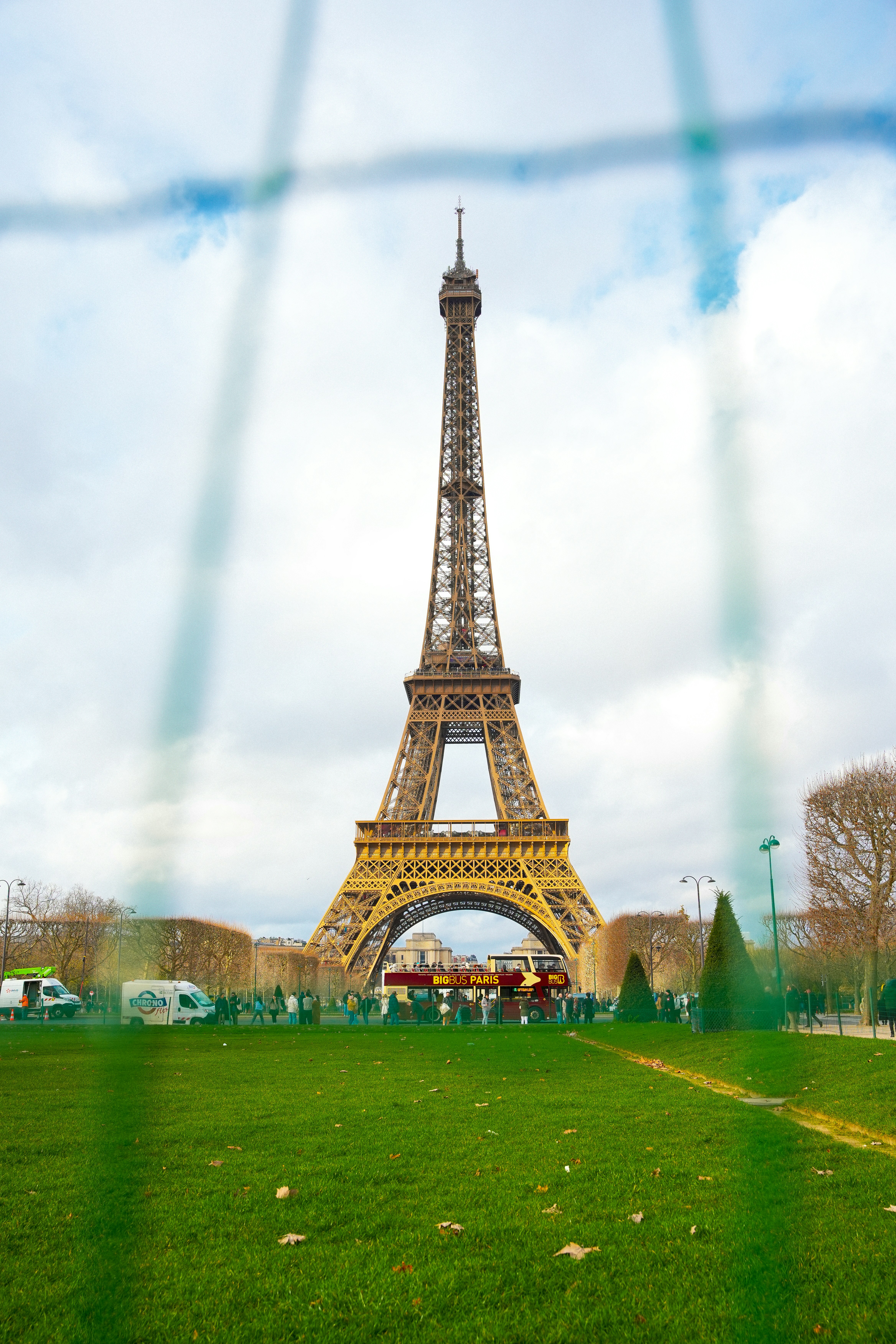 a view of the eiffel tower through a fence