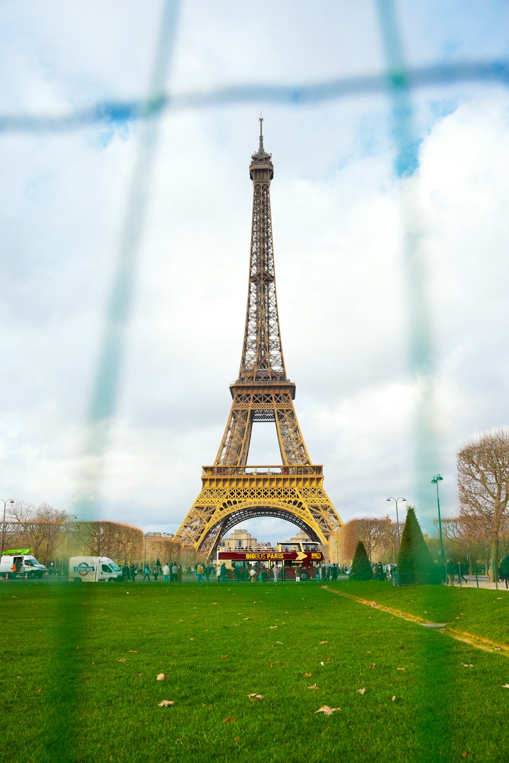 a view of the eiffel tower through a fence