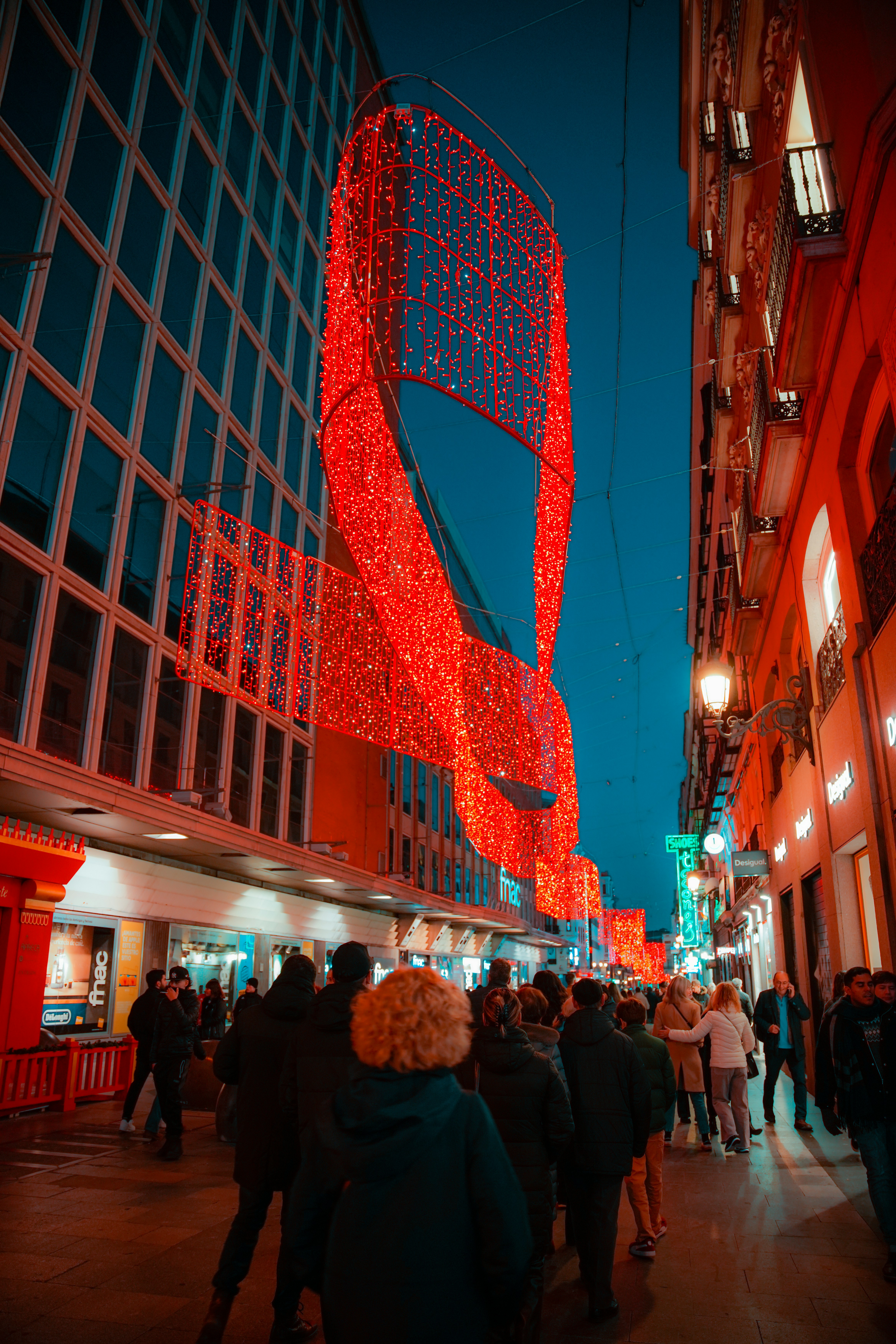 a group of people walking down a street next to tall buildings