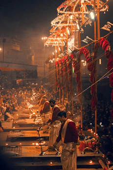 People performing a ritual with oil lamps on the banks of the Ganges in Varanasi