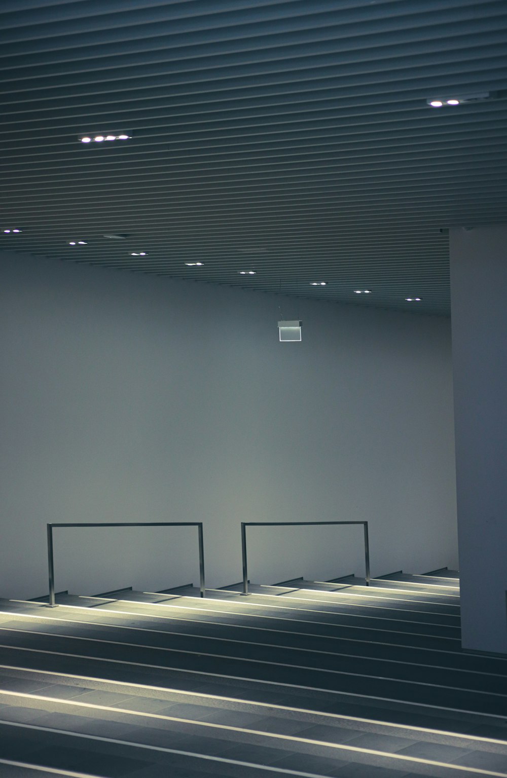 an empty room with a metal railing and white walls
