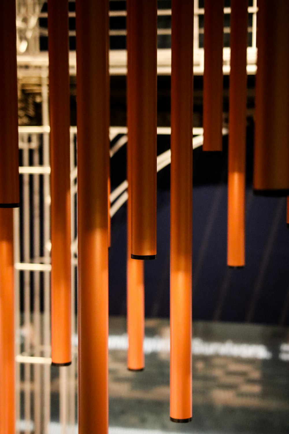 a bunch of orange poles hanging from a ceiling