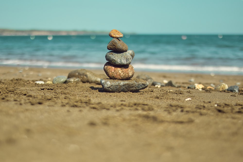 a stack of rocks sitting on top of a sandy beach