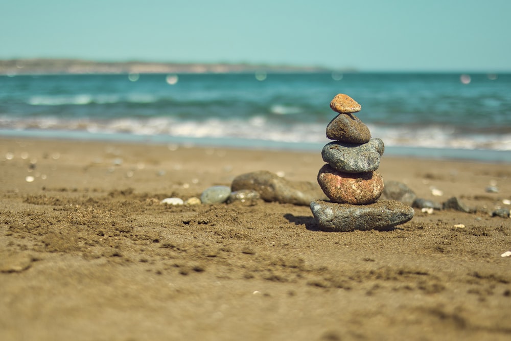 a stack of rocks sitting on top of a sandy beach