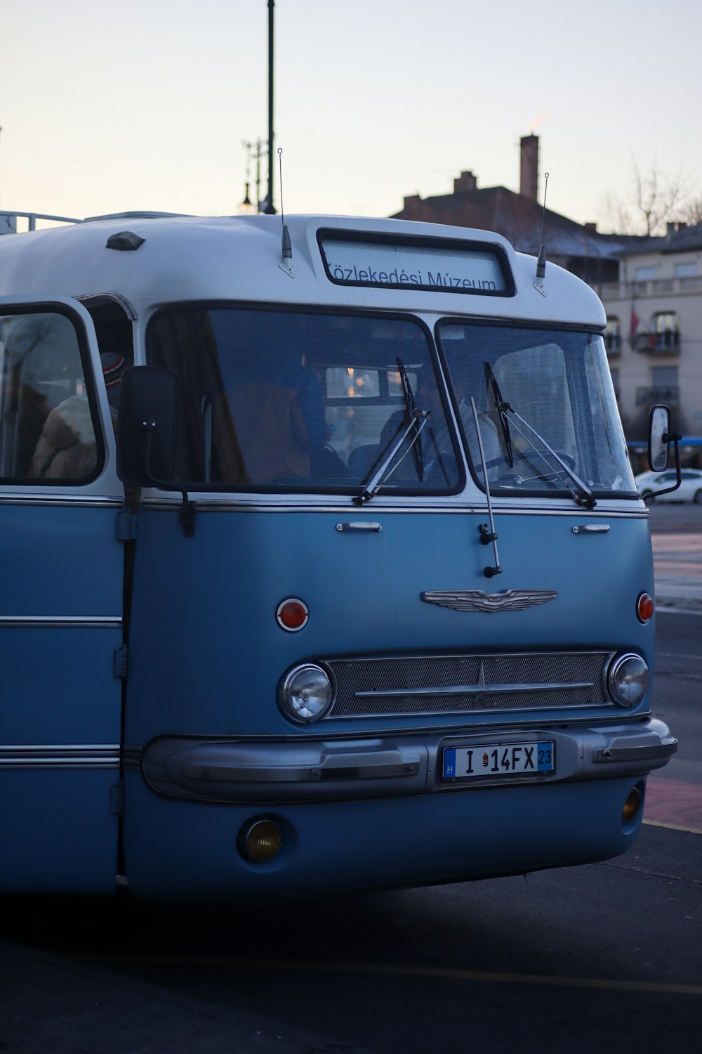 a blue bus parked on the side of the road
