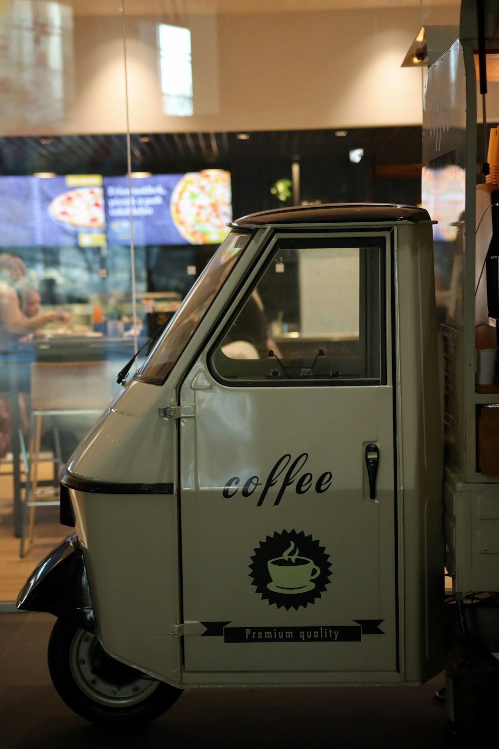 a small white truck with a coffee logo on the side