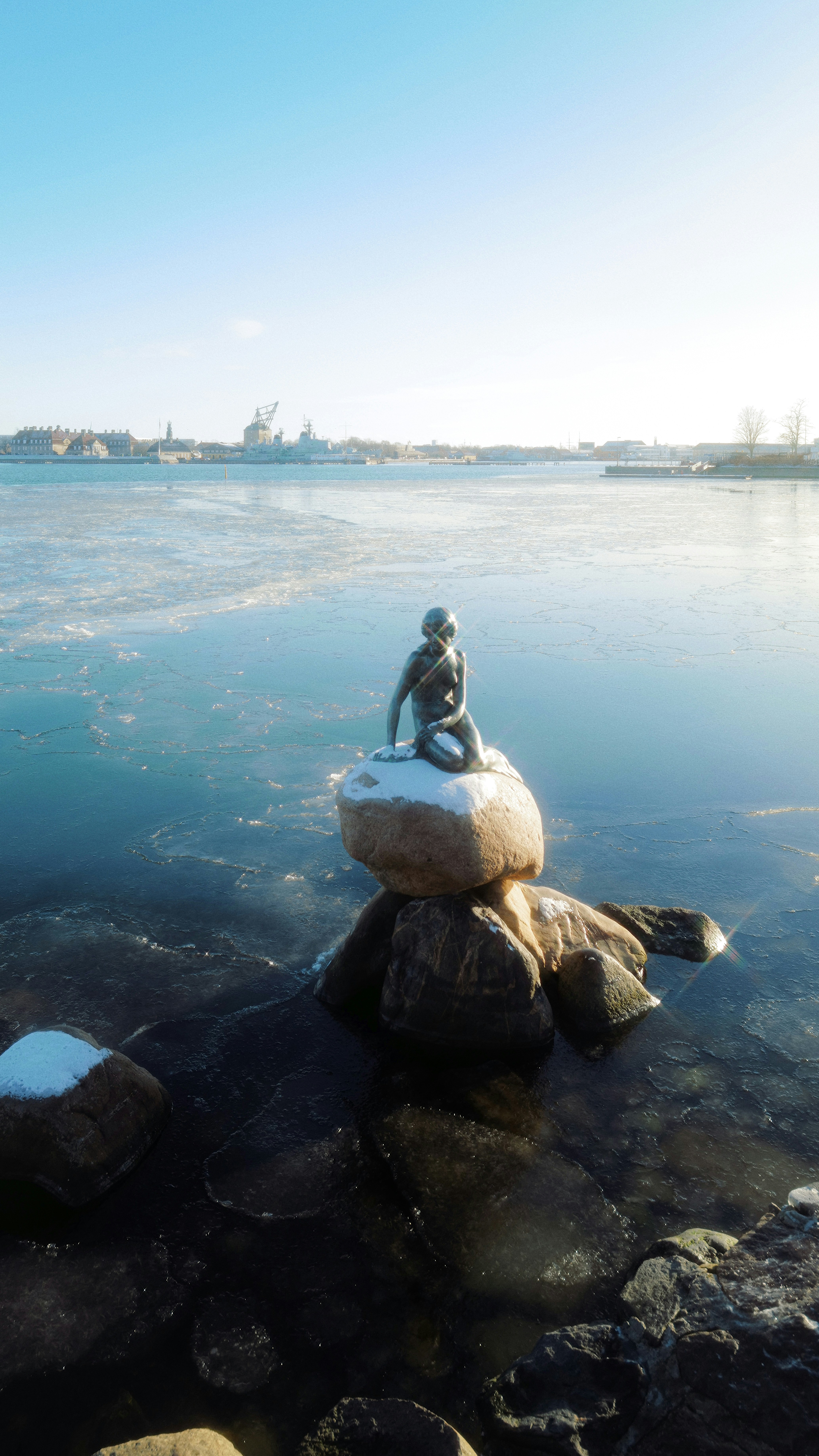 a statue of a person sitting on top of a rock