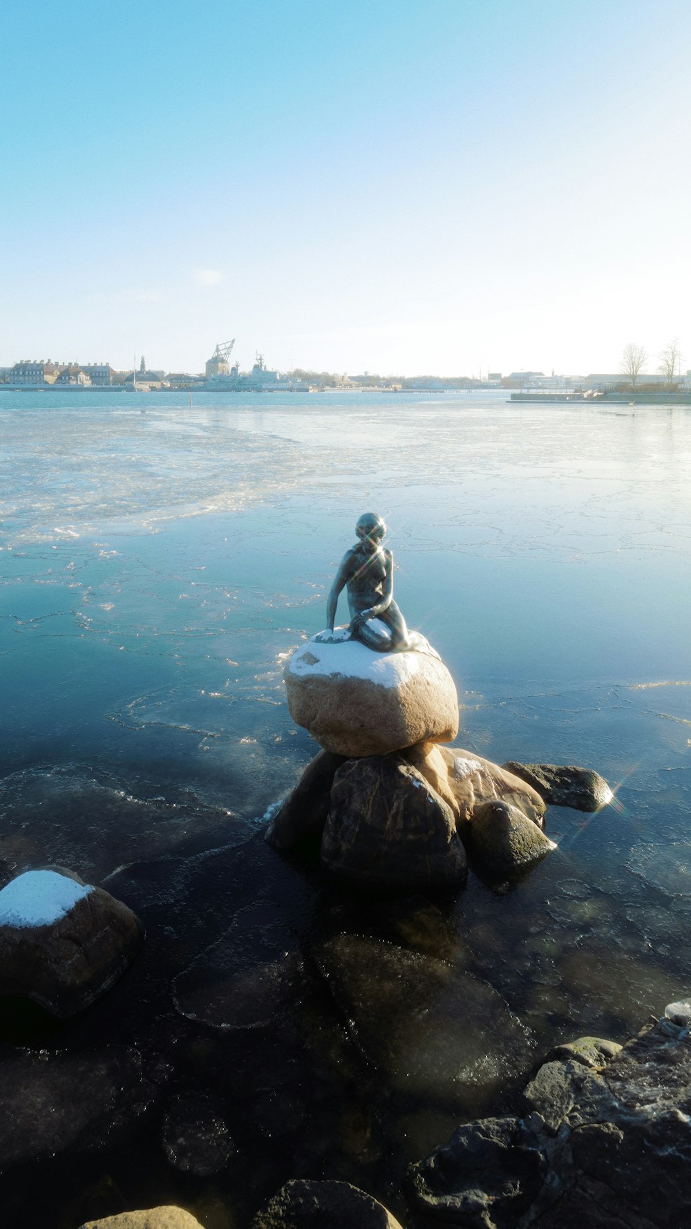 a statue of a person sitting on top of a rock