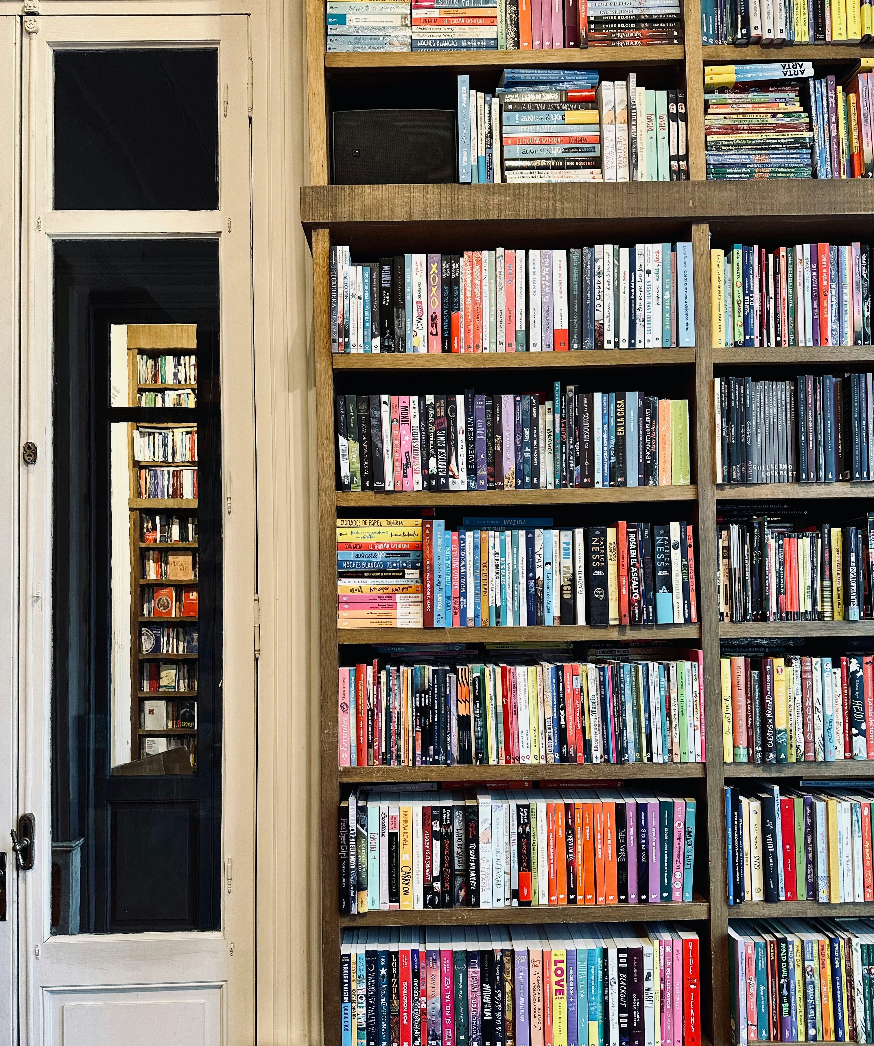 Étagère de bibliothèque avec livres colorés bien rangés dans une pièce lumineuse
