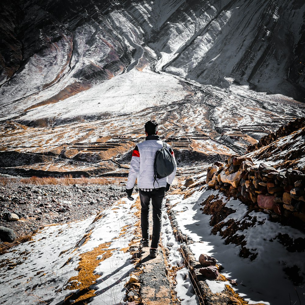 ein Mann, der einen schneebedeckten Berg hinaufgeht