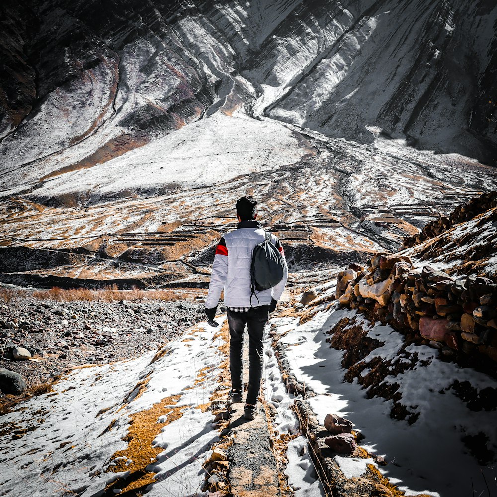 a man walking up a snow covered mountain