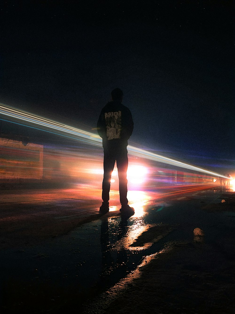 a man standing in the middle of a street at night