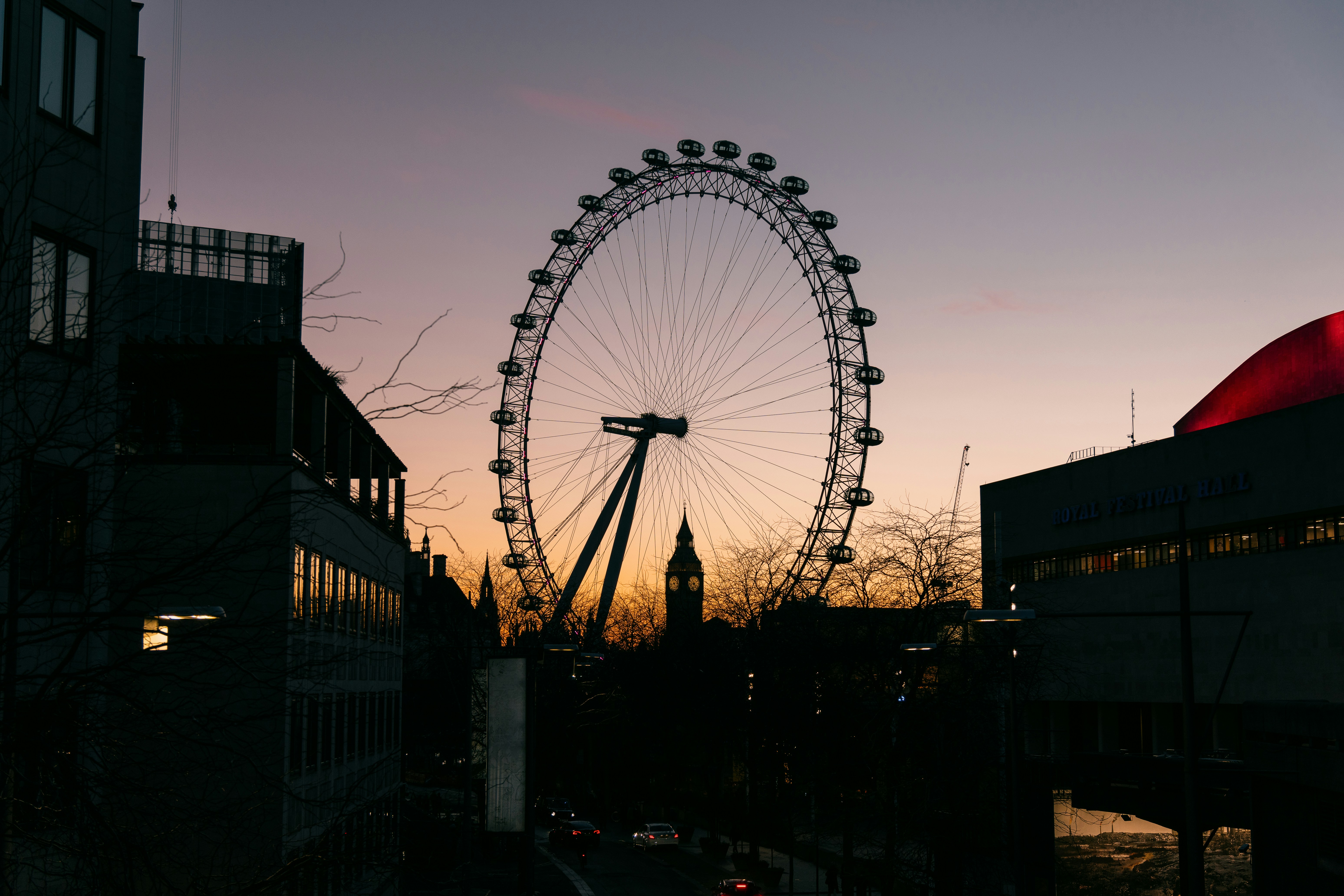 a large ferris wheel sitting next to a tall building