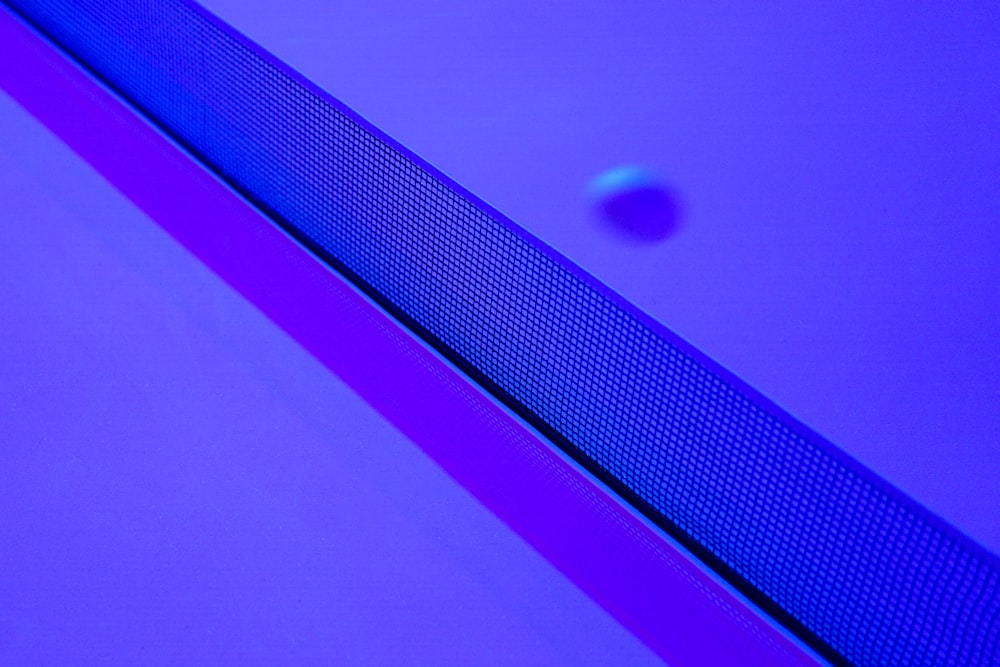 a tennis ball sitting on top of a purple surface