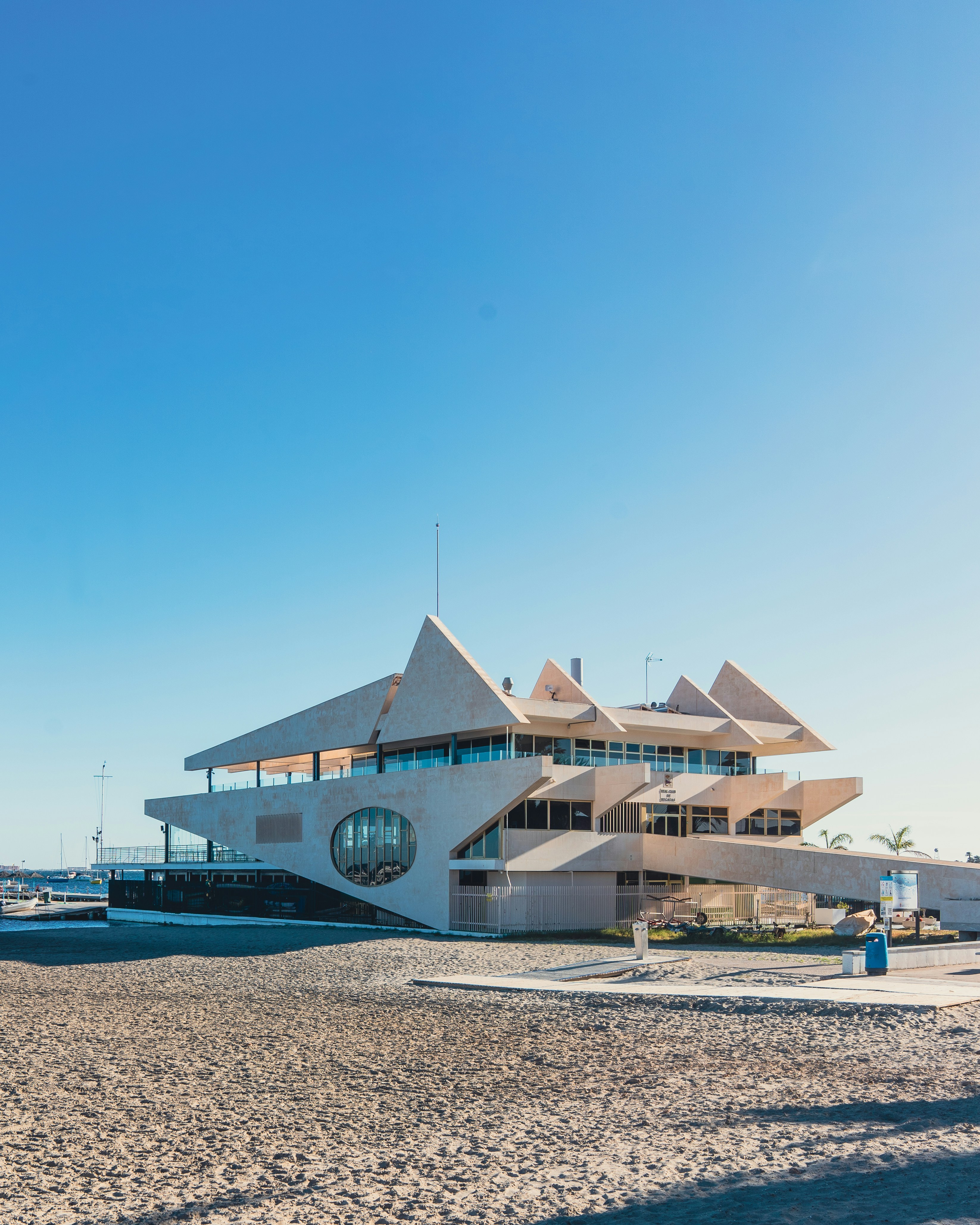 a large white building sitting on top of a sandy beach