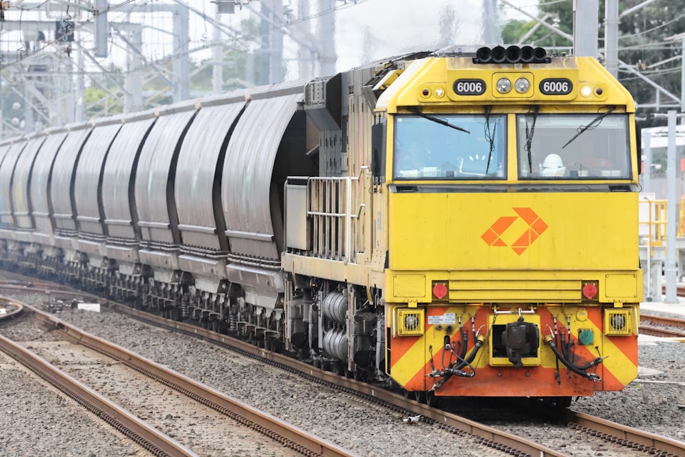 a yellow and black train traveling down train tracks