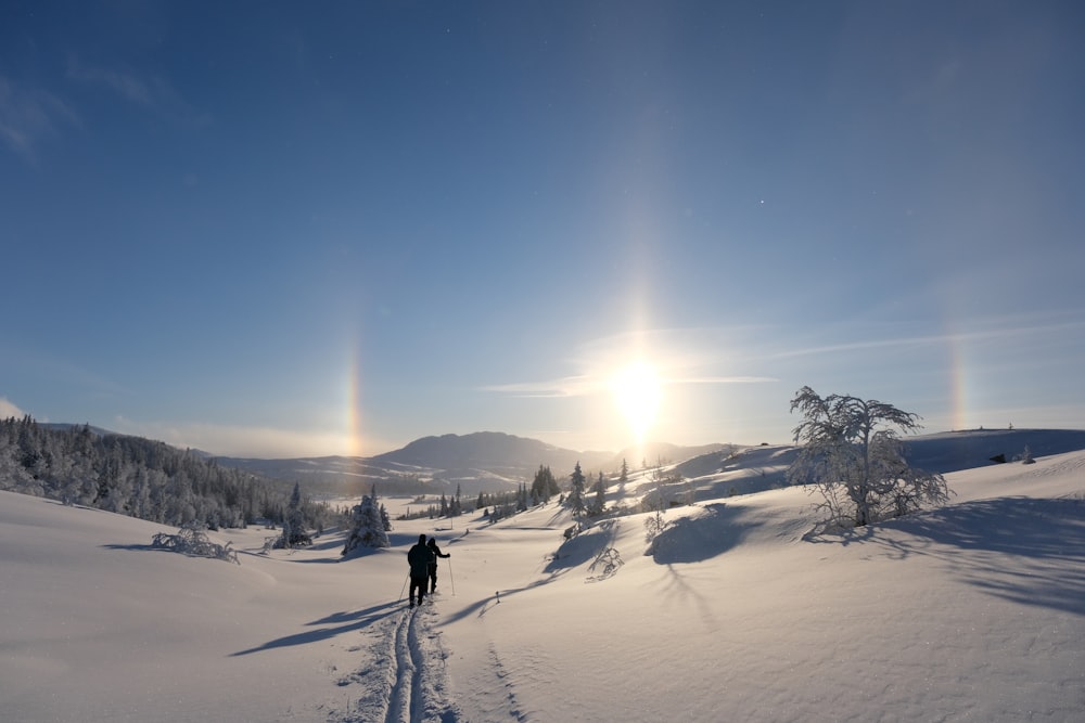 a person walking across a snow covered field