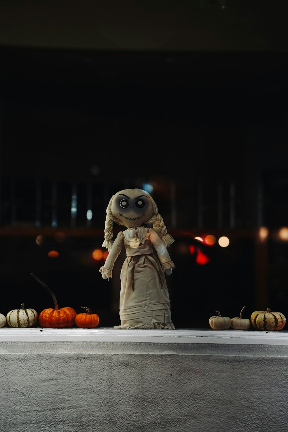 a stuffed animal is standing in front of pumpkins