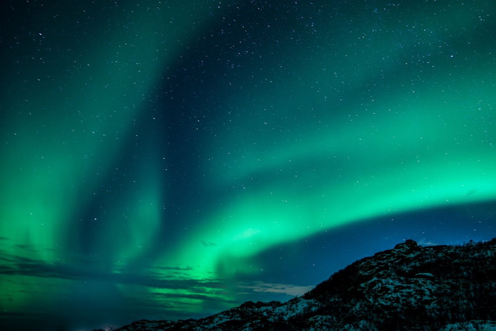 a green and blue aurora bore in the night sky