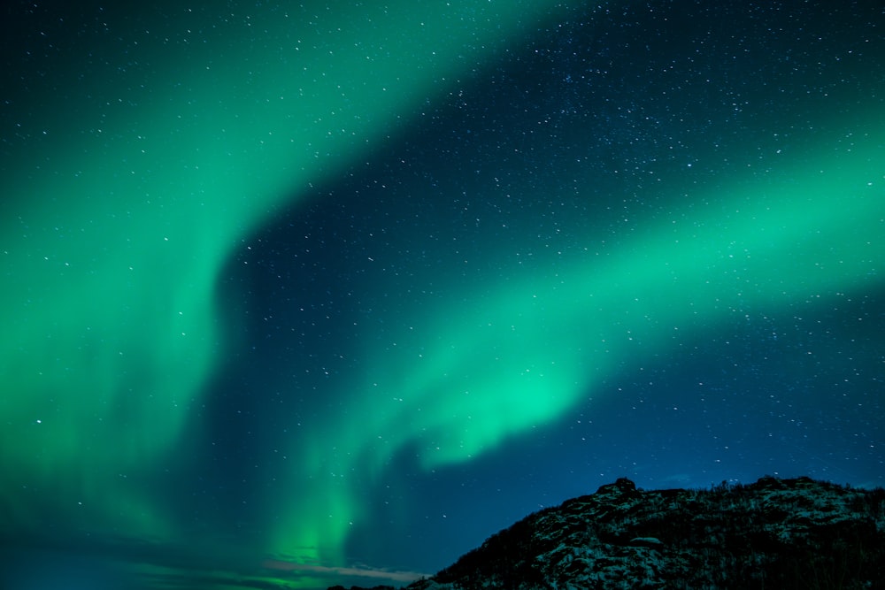 Un cielo verde y azul lleno de muchas estrellas