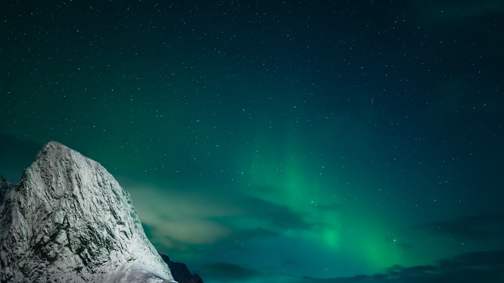a mountain with a green light in the sky