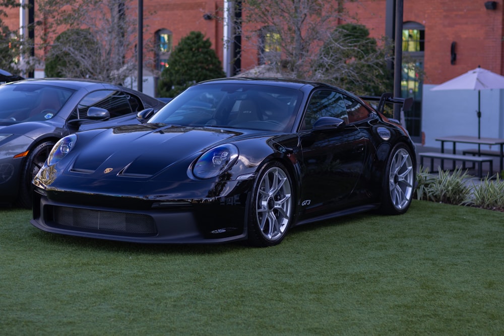 a couple of black sports cars parked next to each other