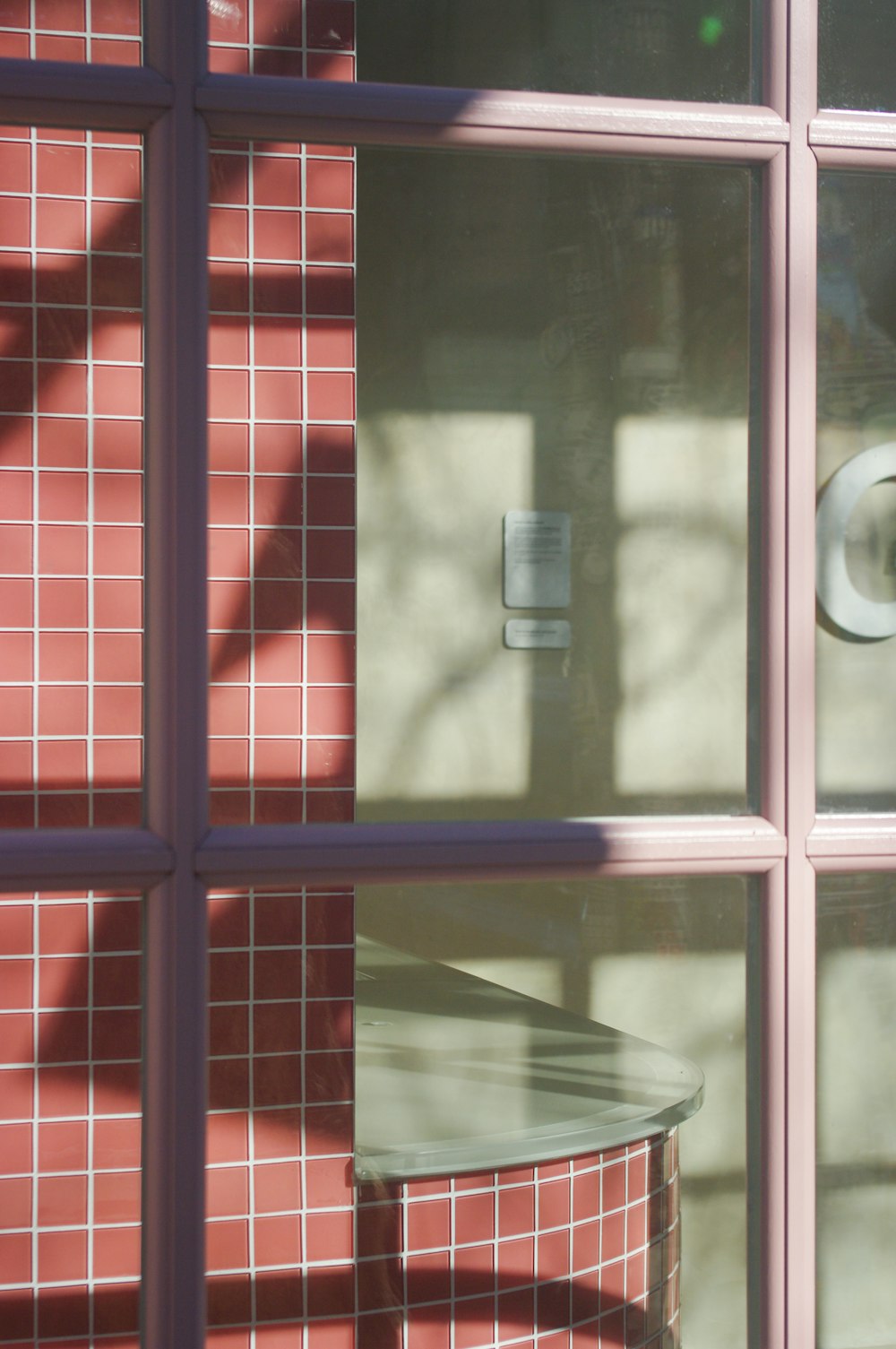 the reflection of a toilet paper roll in a window