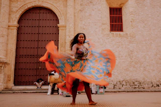 a woman is dancing in front of a building