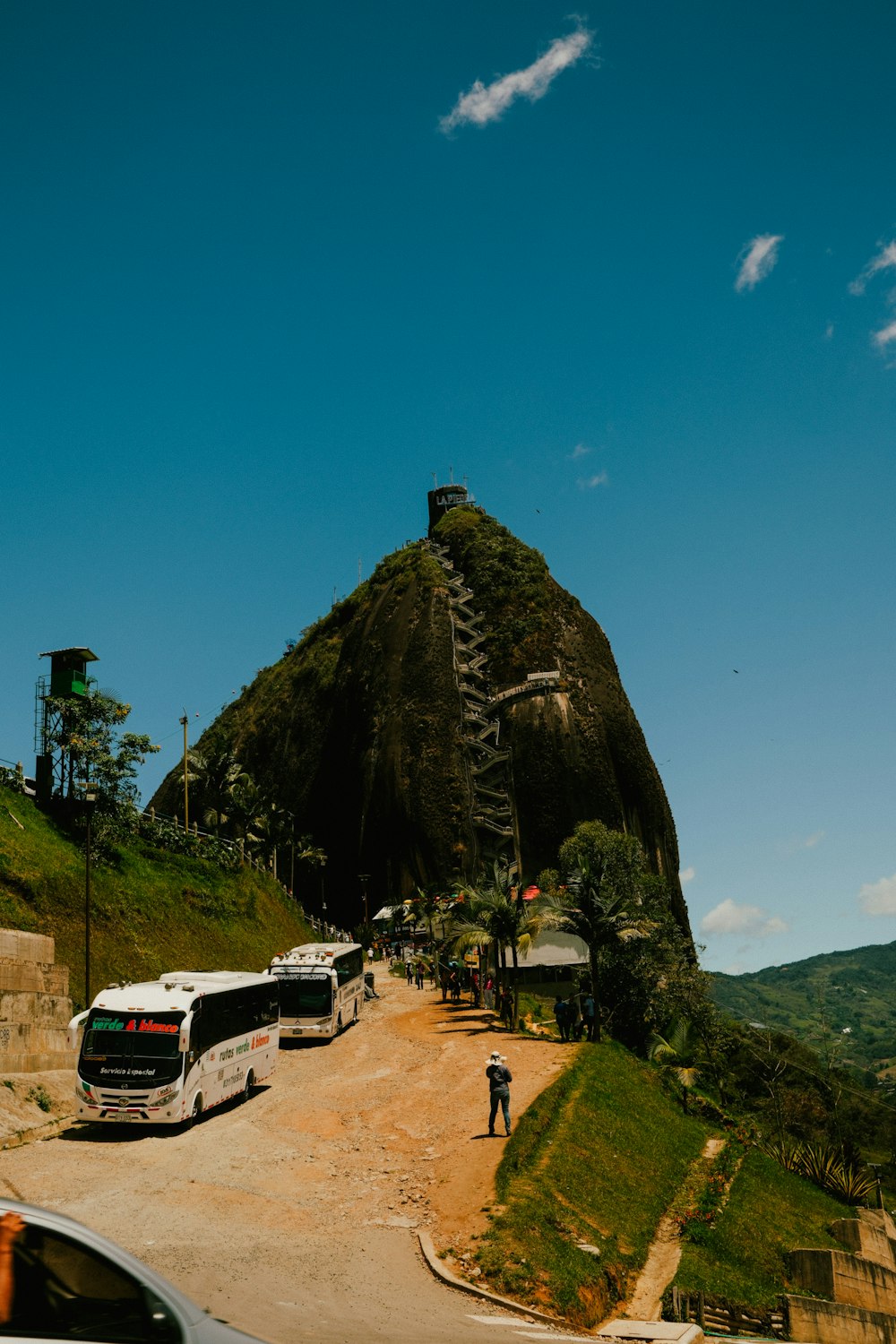 a group of buses driving down a dirt road