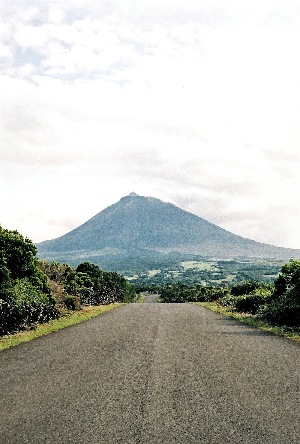 uma estrada vazia com uma montanha ao fundo