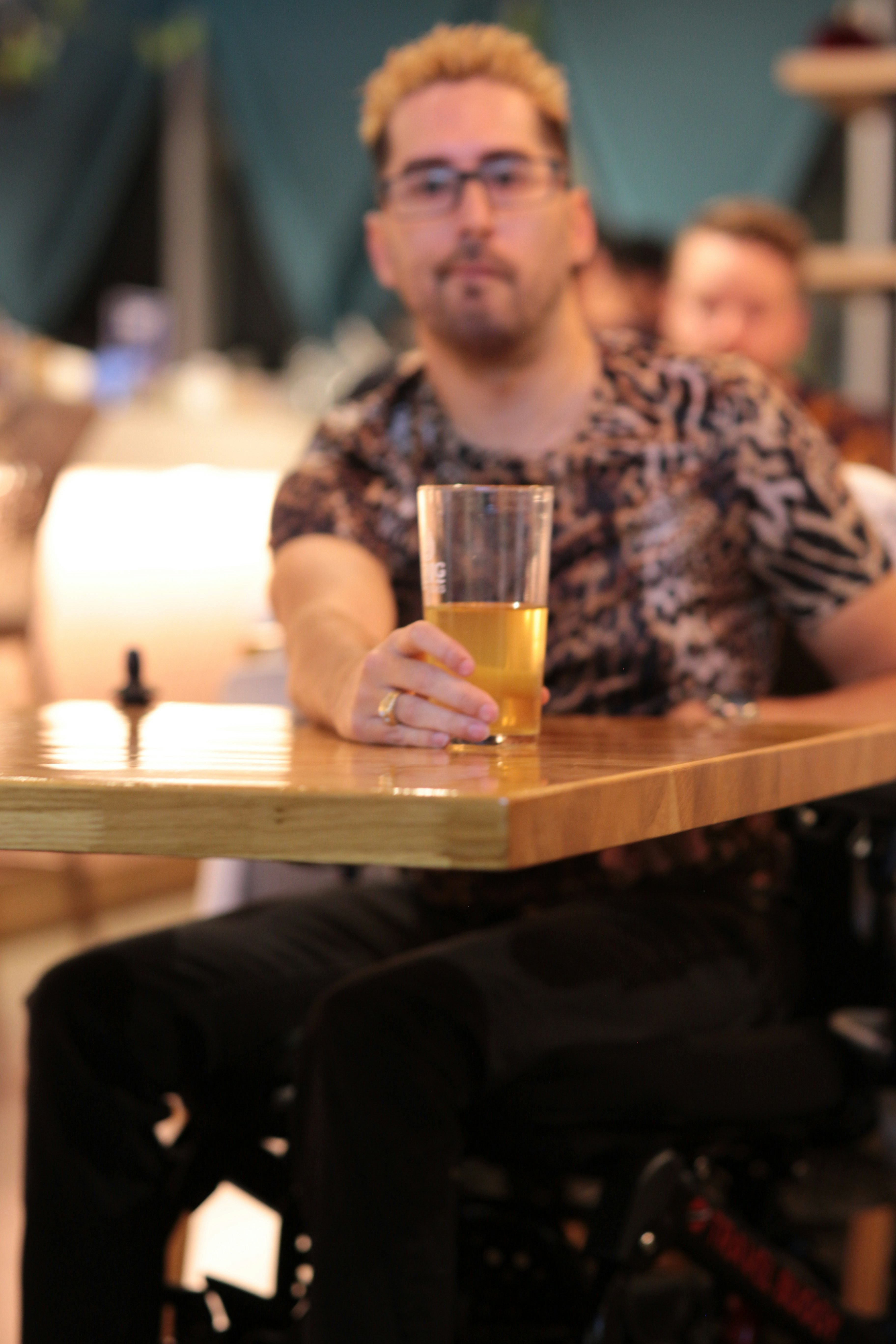 a man sitting at a table with a glass of beer
