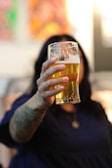 a woman holding a glass of beer in front of her face