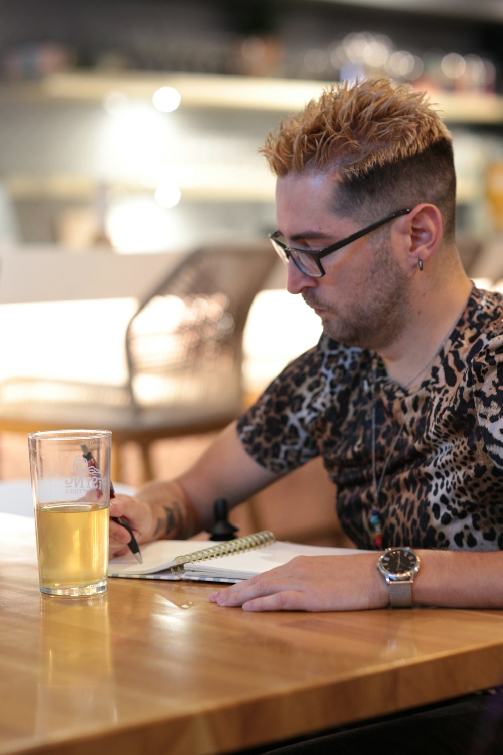 a man sitting at a table with a glass of beer