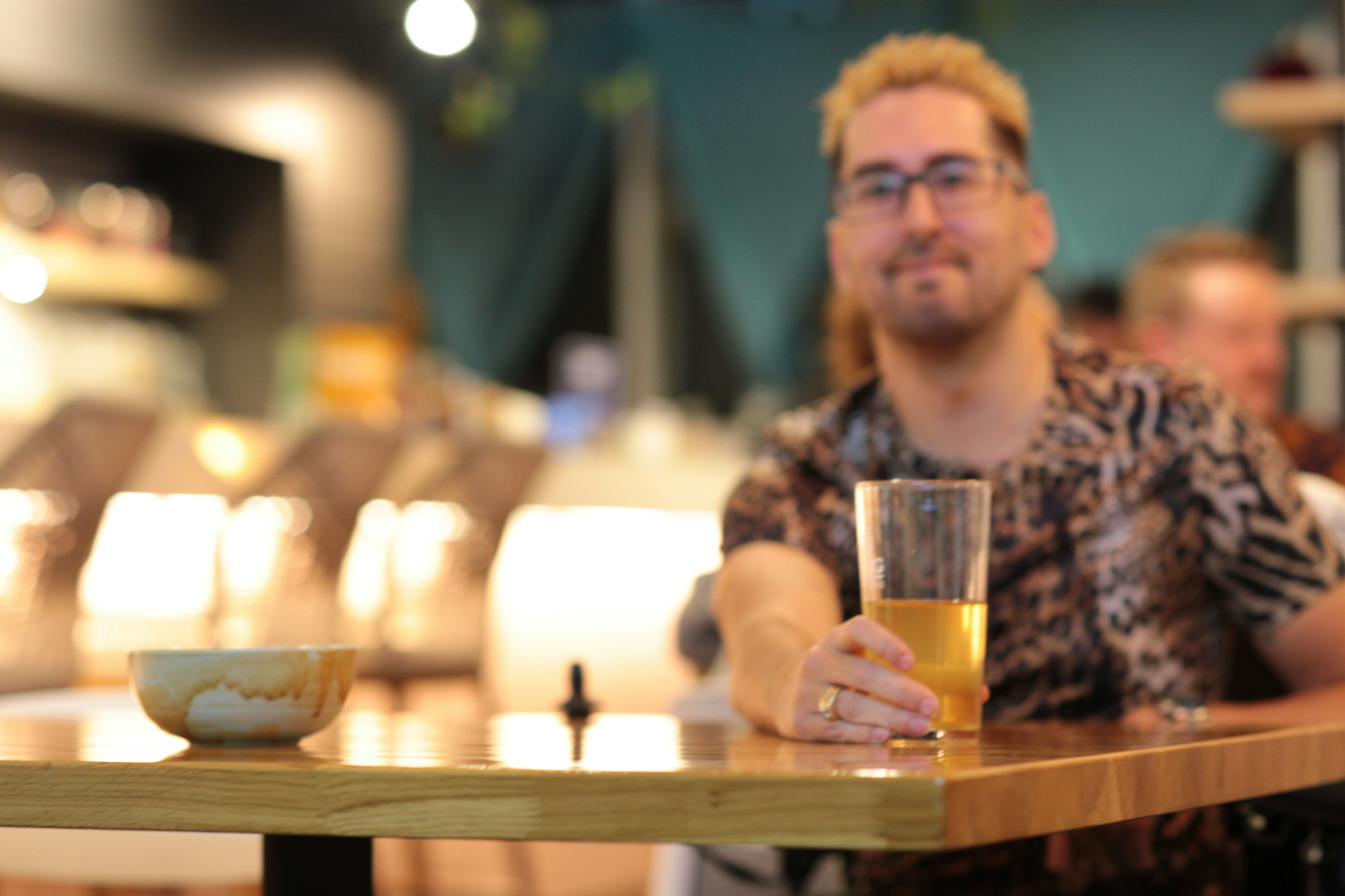 a man sitting at a table with a glass of beer