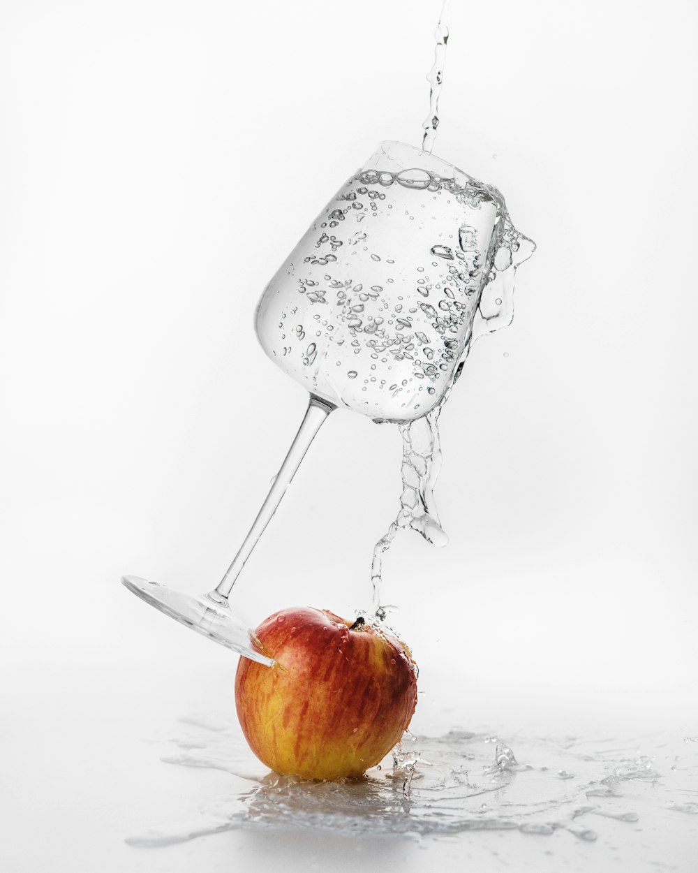 an apple being dropped into a glass of water