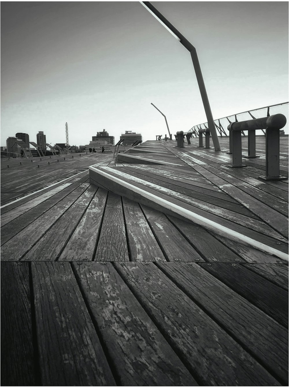 a black and white photo of a boardwalk