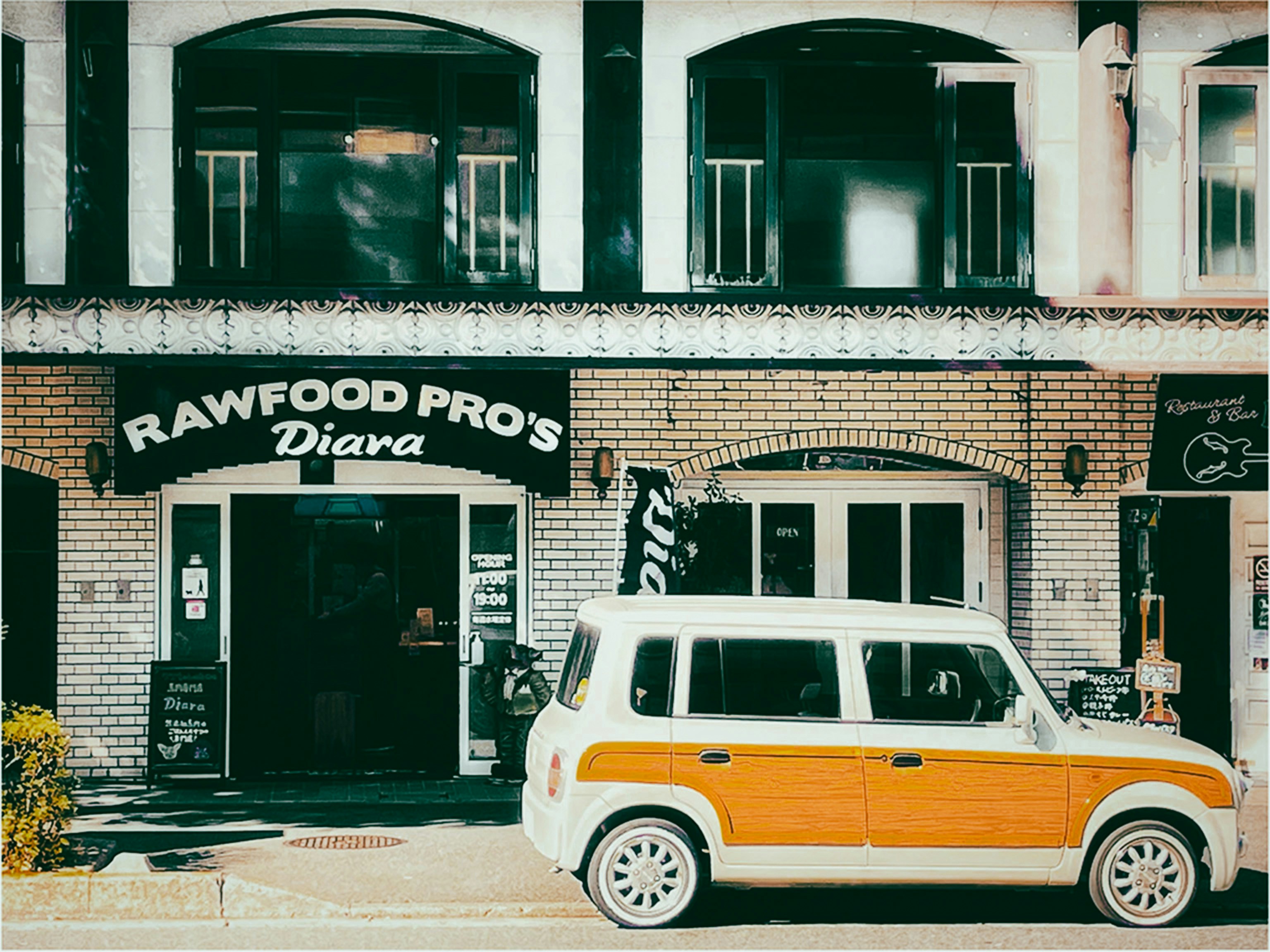 a small white and orange car parked in front of a building