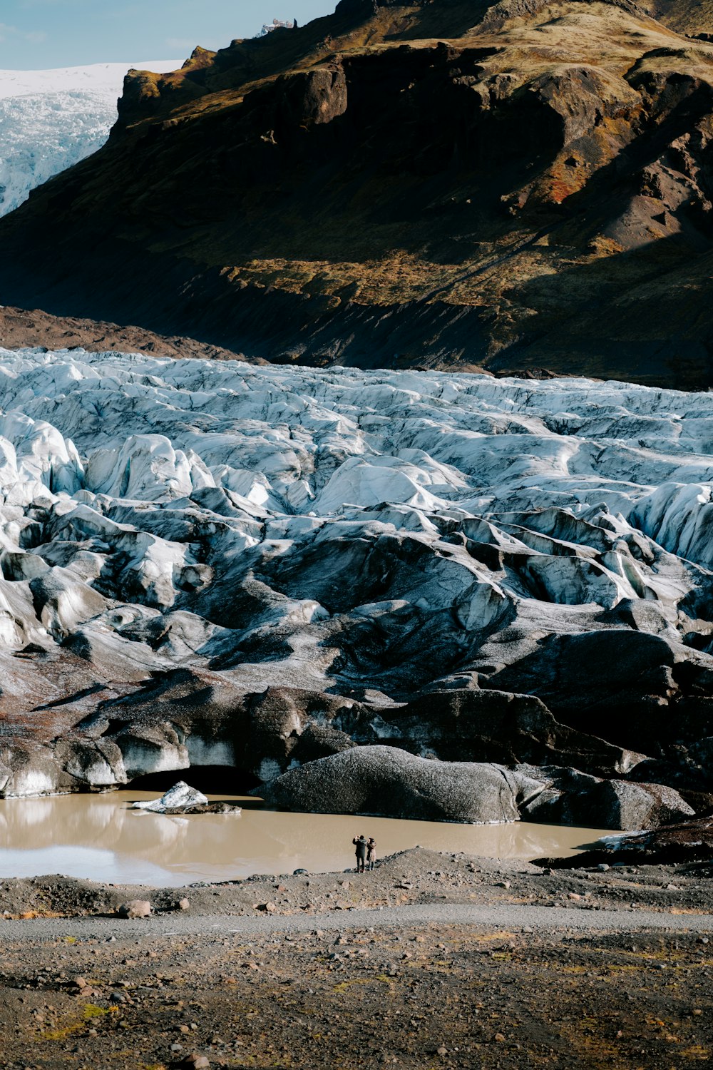 a couple of people standing on top of a glacier