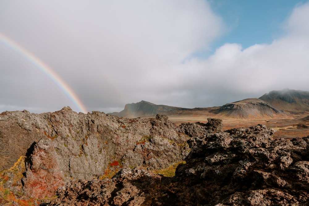 a rainbow in the sky over a mountain range