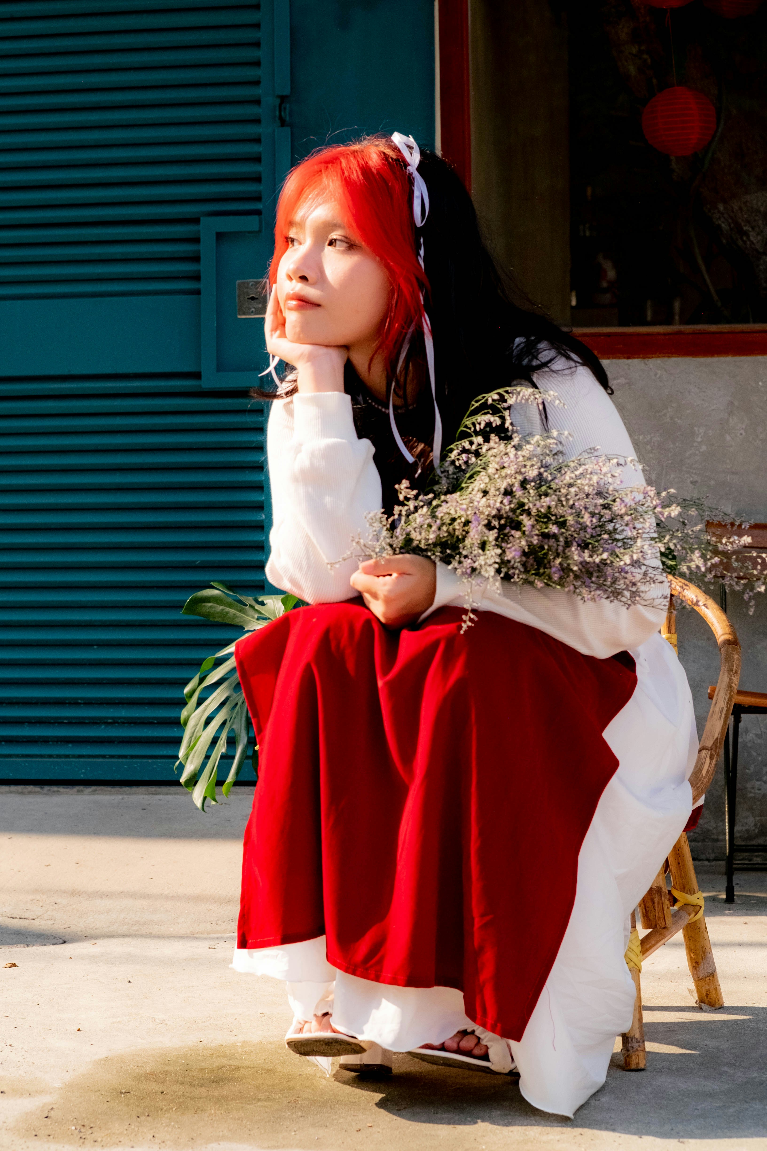 seorang wanita berambut merah duduk di kursi