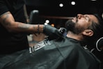 a man getting his hair cut at a barber shop