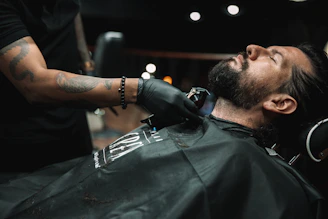 a man getting his hair cut at a barber shop