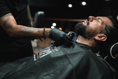 a man getting his hair cut at a barber shop