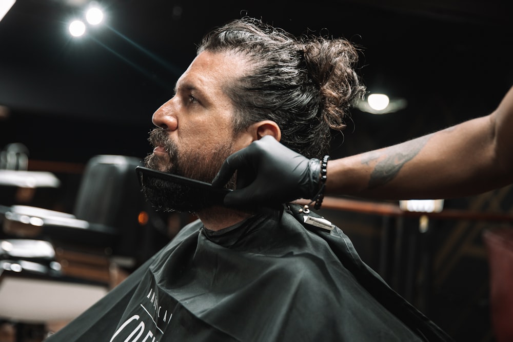 a man getting his hair cut at a barber shop