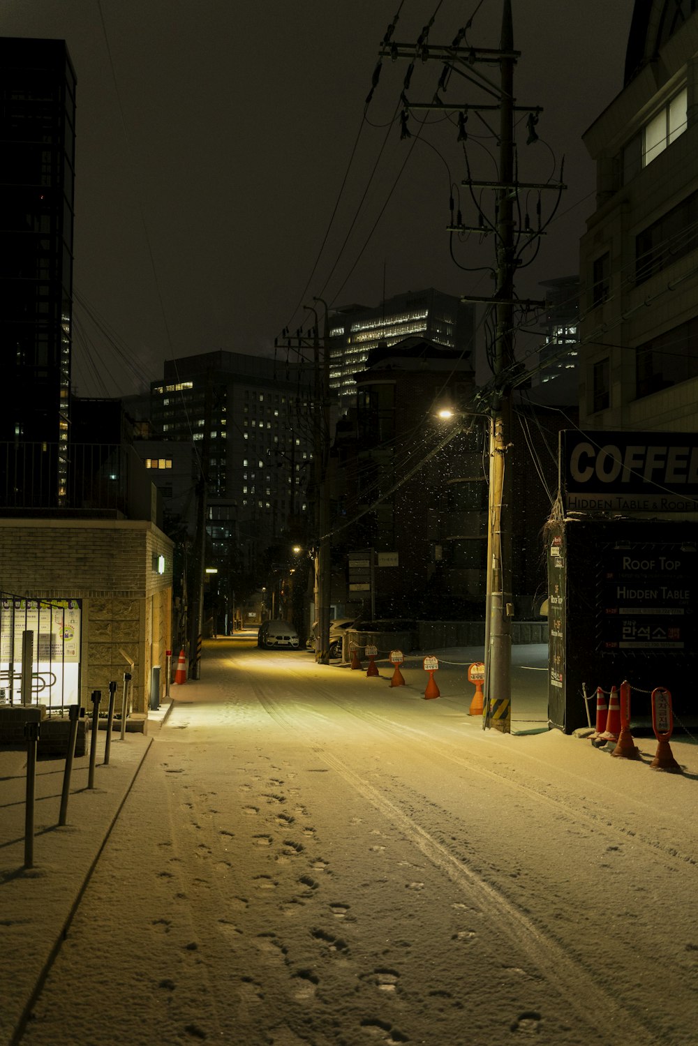 a city street at night with snow on the ground